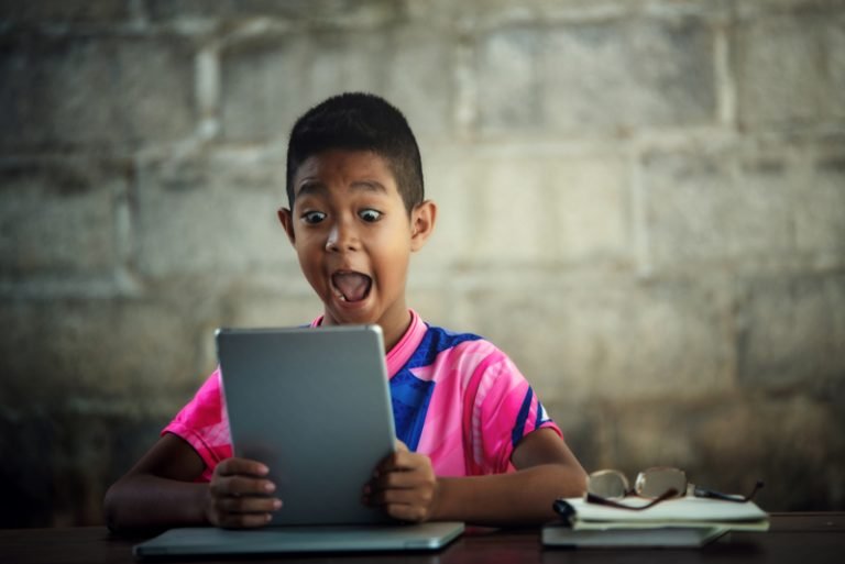 National Public School, Varthur Asian boy using laptop on the table,come back to shcool